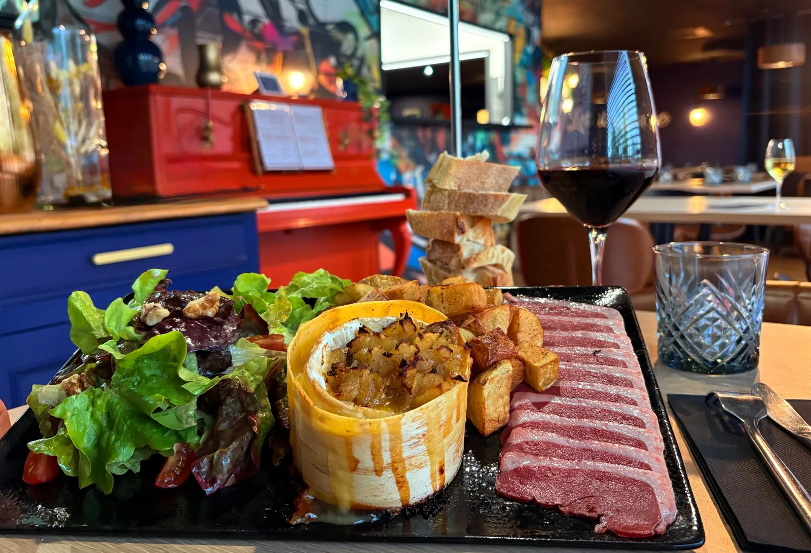 Camembert rôti Périgourdin servi au restaurant Let it Brie en Vendée avec salade, pommes de terre et magret de canard.