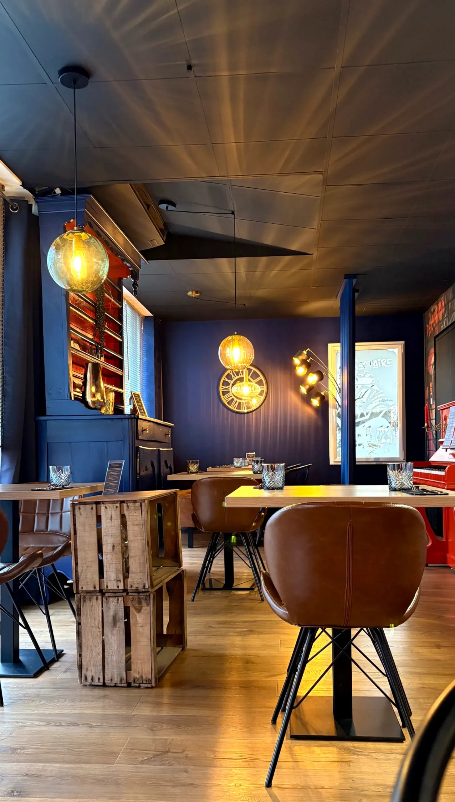 Salle chaleureuse du restaurant Let it Brie aux Herbiers avec sa décoration élégante et son piano rouge.