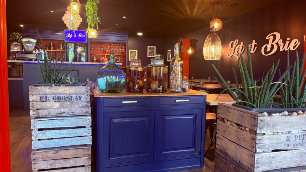 Salle du restaurant Let it Brie aux Herbiers avec décoration chaleureuse et logo sur le mur