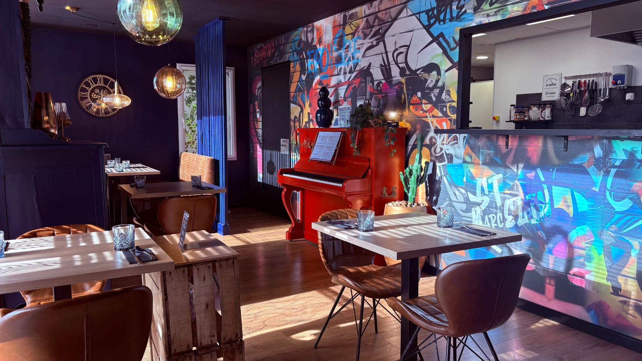 Salle du restaurant Let it Brie aux Herbiers avec piano rouge et cuisine ouverte